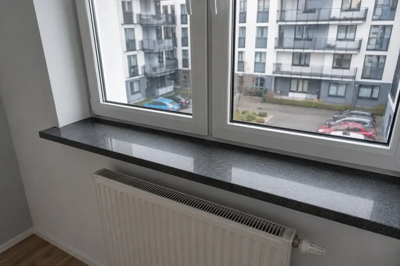 Parapet wewnętrzny z szarego granitu nad grzejnikiem — realizacja LEMSTONE